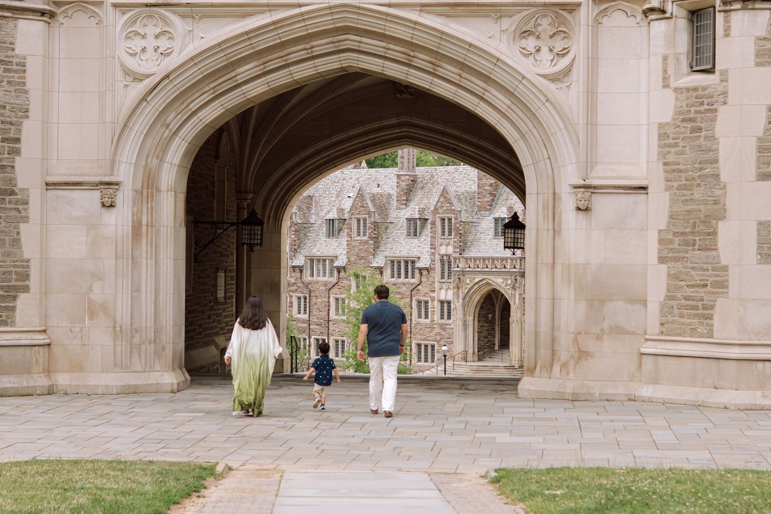 A happy family holding hands and walking together outdoors through the scenic campus grounds at Princeton University in New Jersey.
