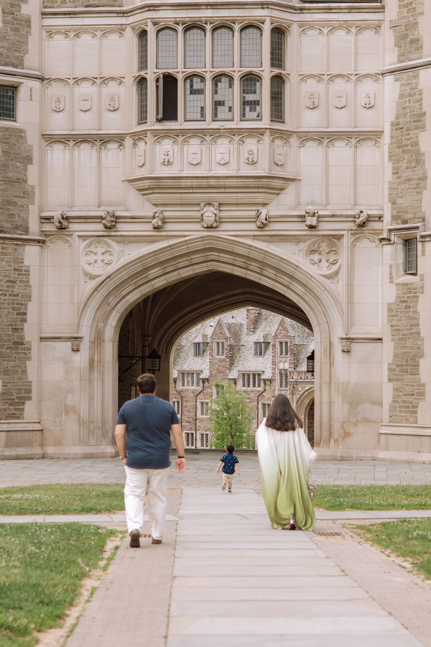 A happy family holding hands and walking together outdoors through the scenic campus grounds at Princeton University in New Jersey.