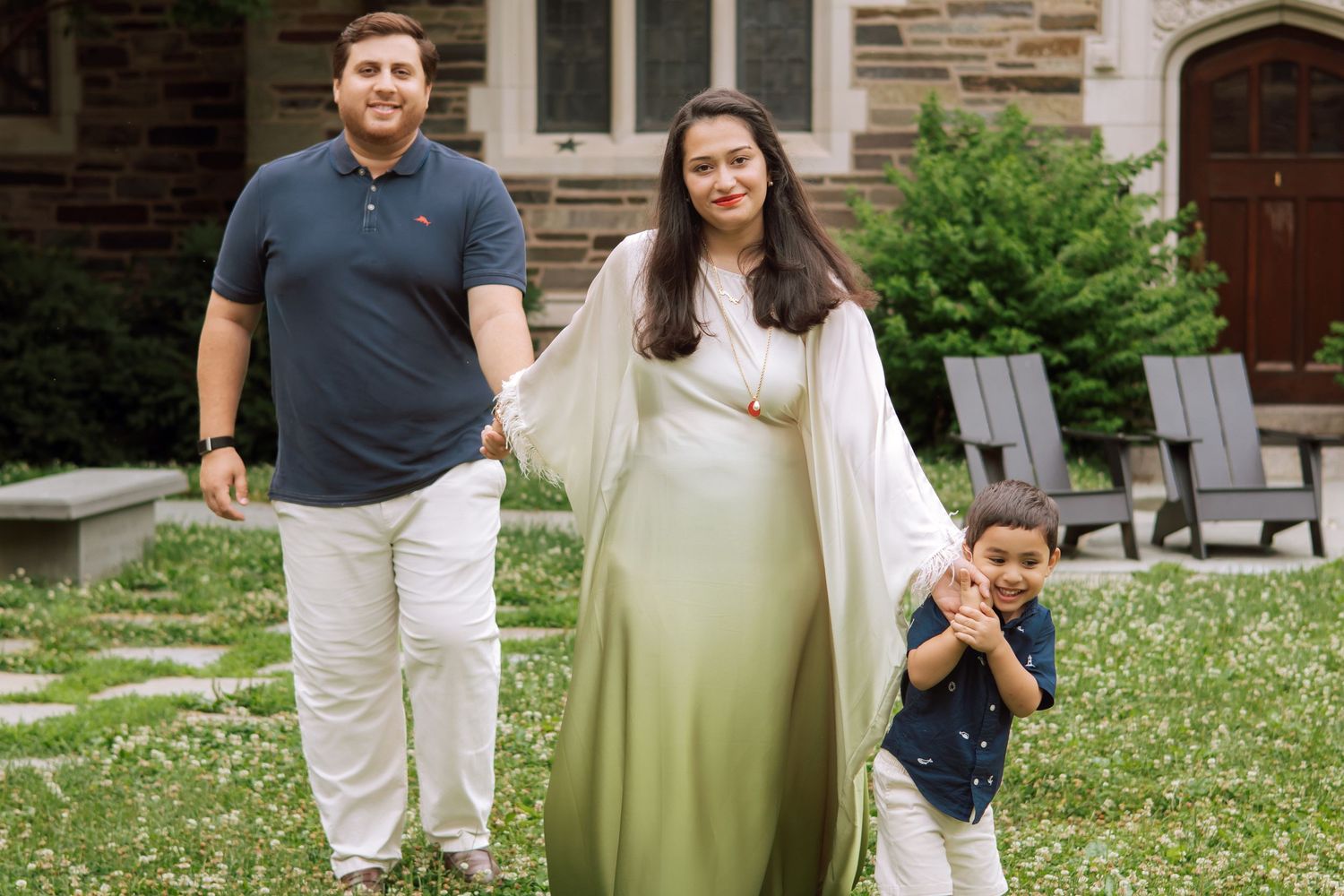 A happy family holding hands and walking together outdoors through the scenic campus grounds at Princeton University in New Jersey.