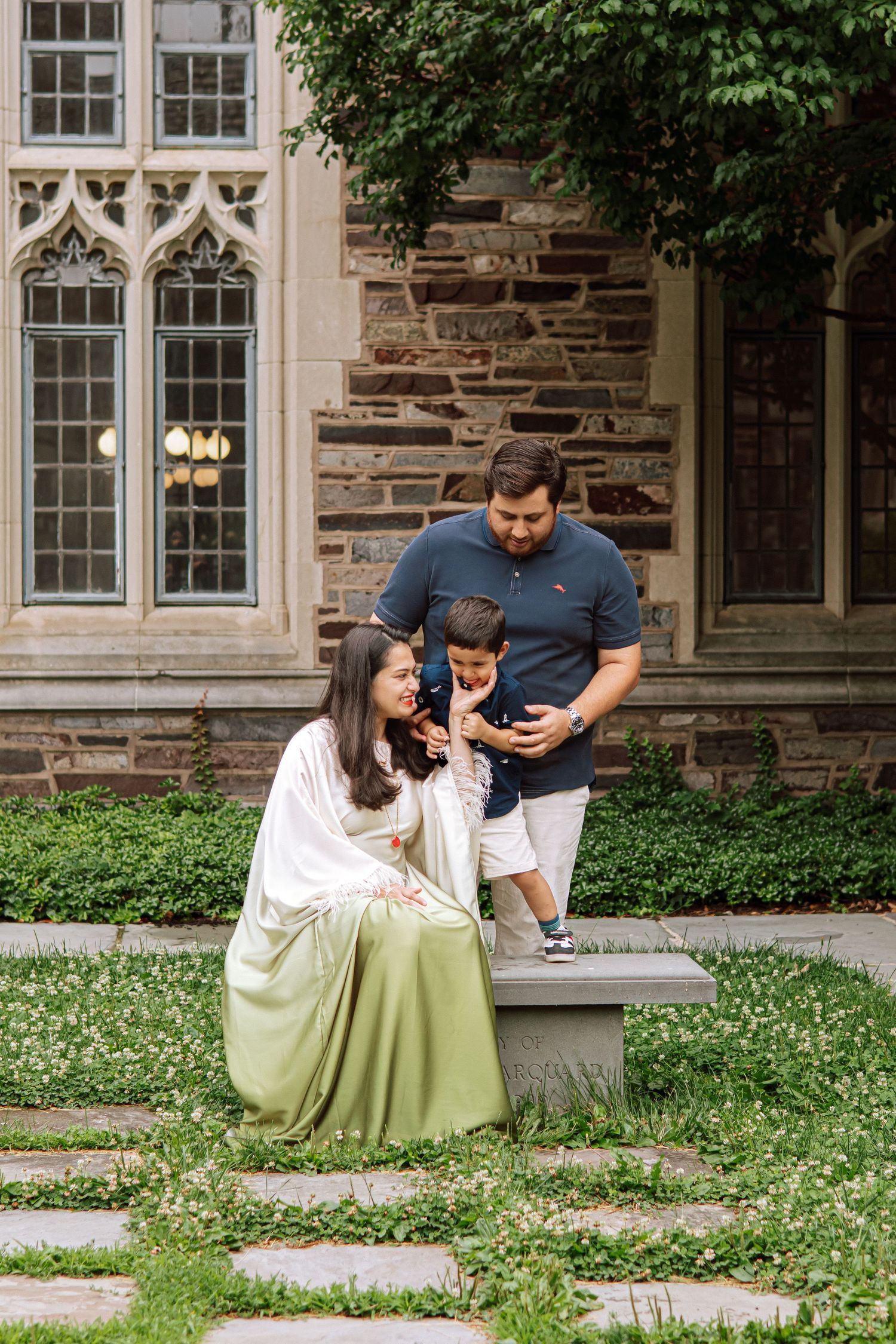 A happy family holding hands and walking together outdoors through the scenic campus grounds at Princeton University in New Jersey.