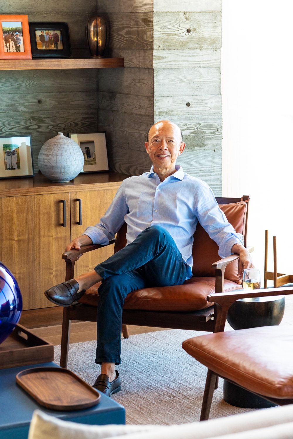 On location lifestyle portrait of a man sitting relaxed in an upscale chair.