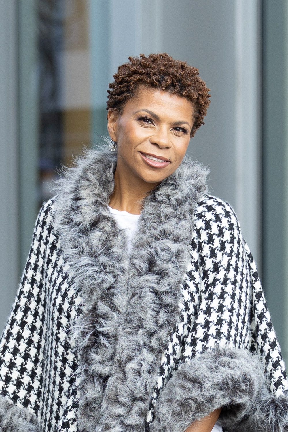 Outdoor portrait of a women wearing a checkered patterned shawl.