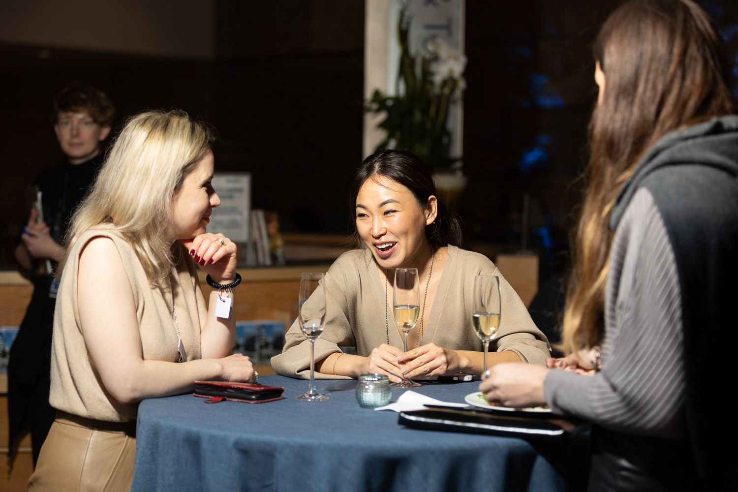 Attendees networking and chatting in a lounge area at a corporate summit.