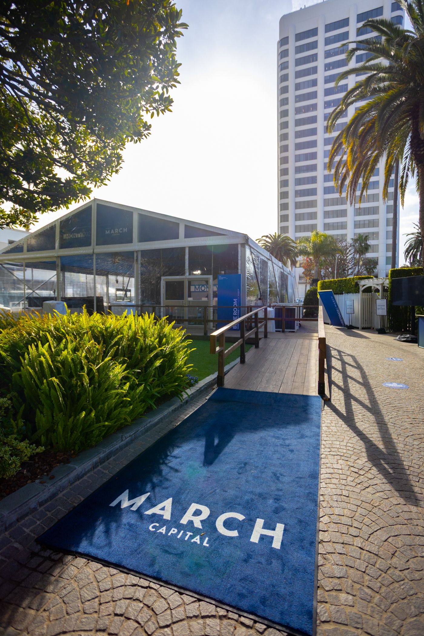 Environmental shot of the entrance to a corporate event with brand name on carpet.