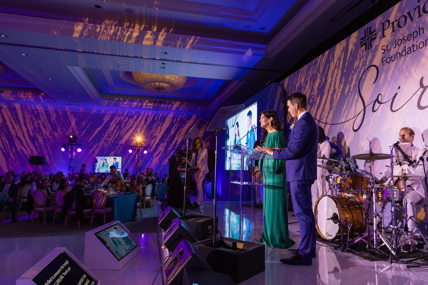Indoor stage presentation at a large corporate gala event.