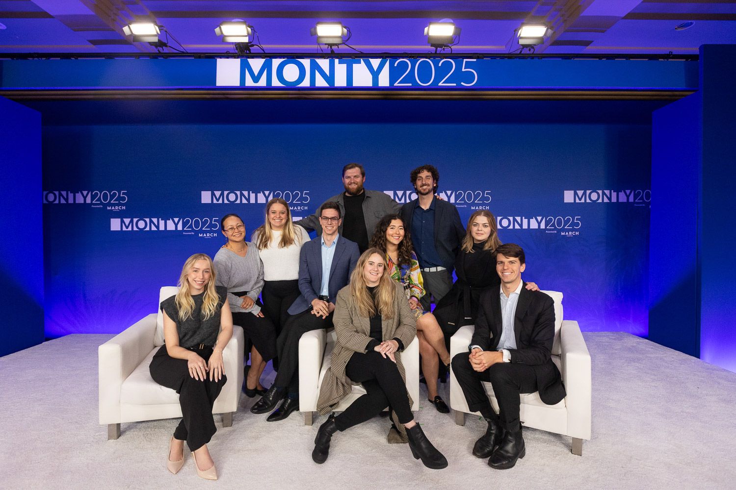 Group portrait of corporate event planners posing on stage.