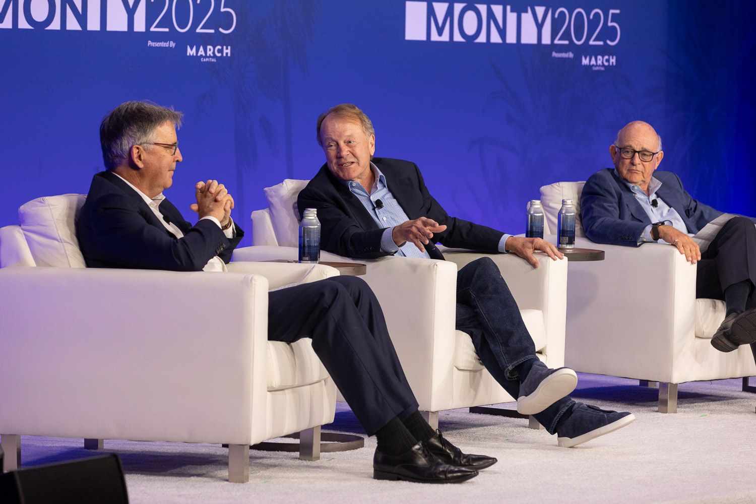 Speakers participating in a panel discussion on stage at a business summit.