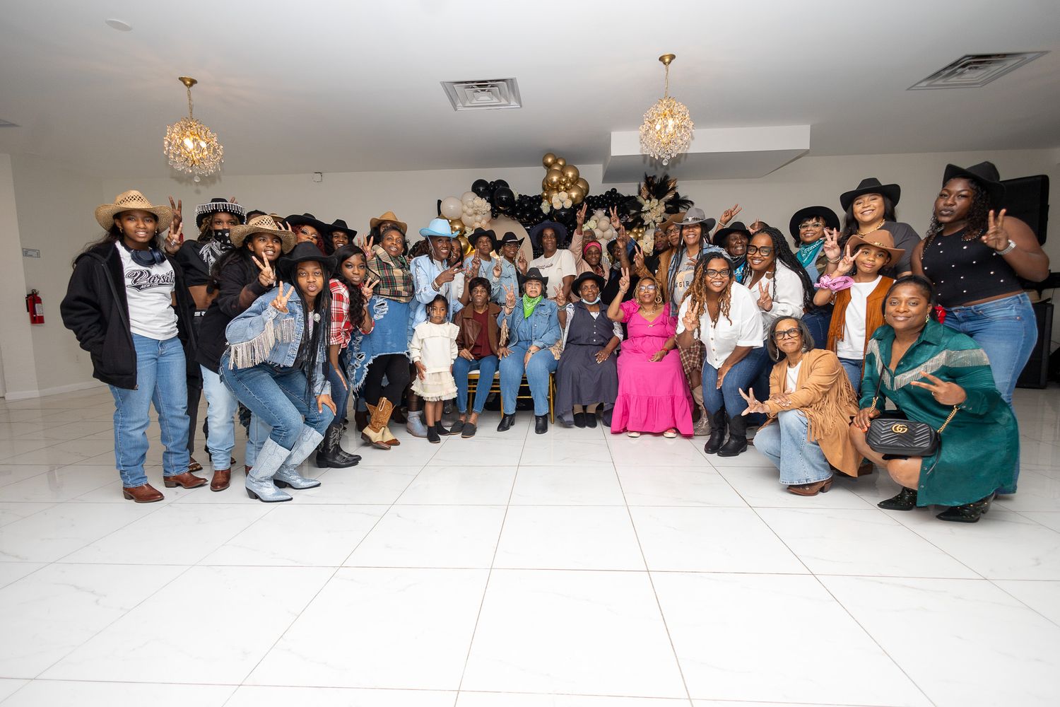 a large group of people posing together indoors, likely for a special event or celebration. They are arranged in a few rows.
