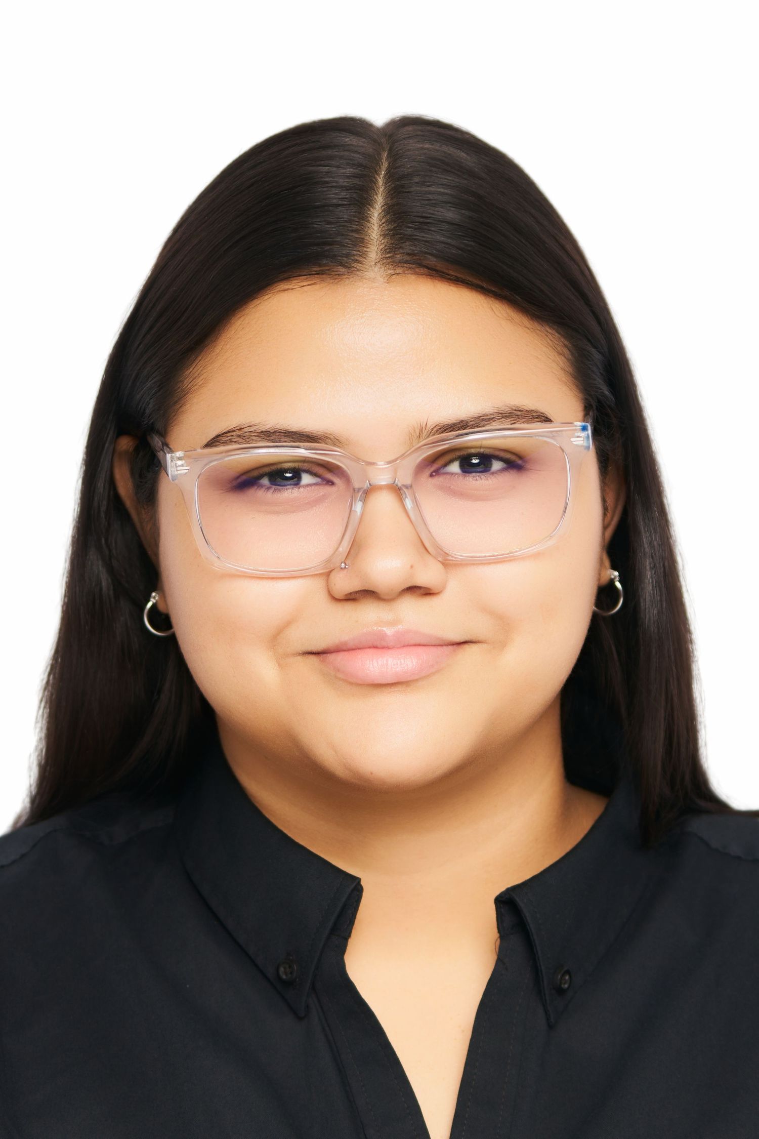 Young woman with long dark hair, clear-framed glasses, and hoop earrings wearing a black shirt against white background.
