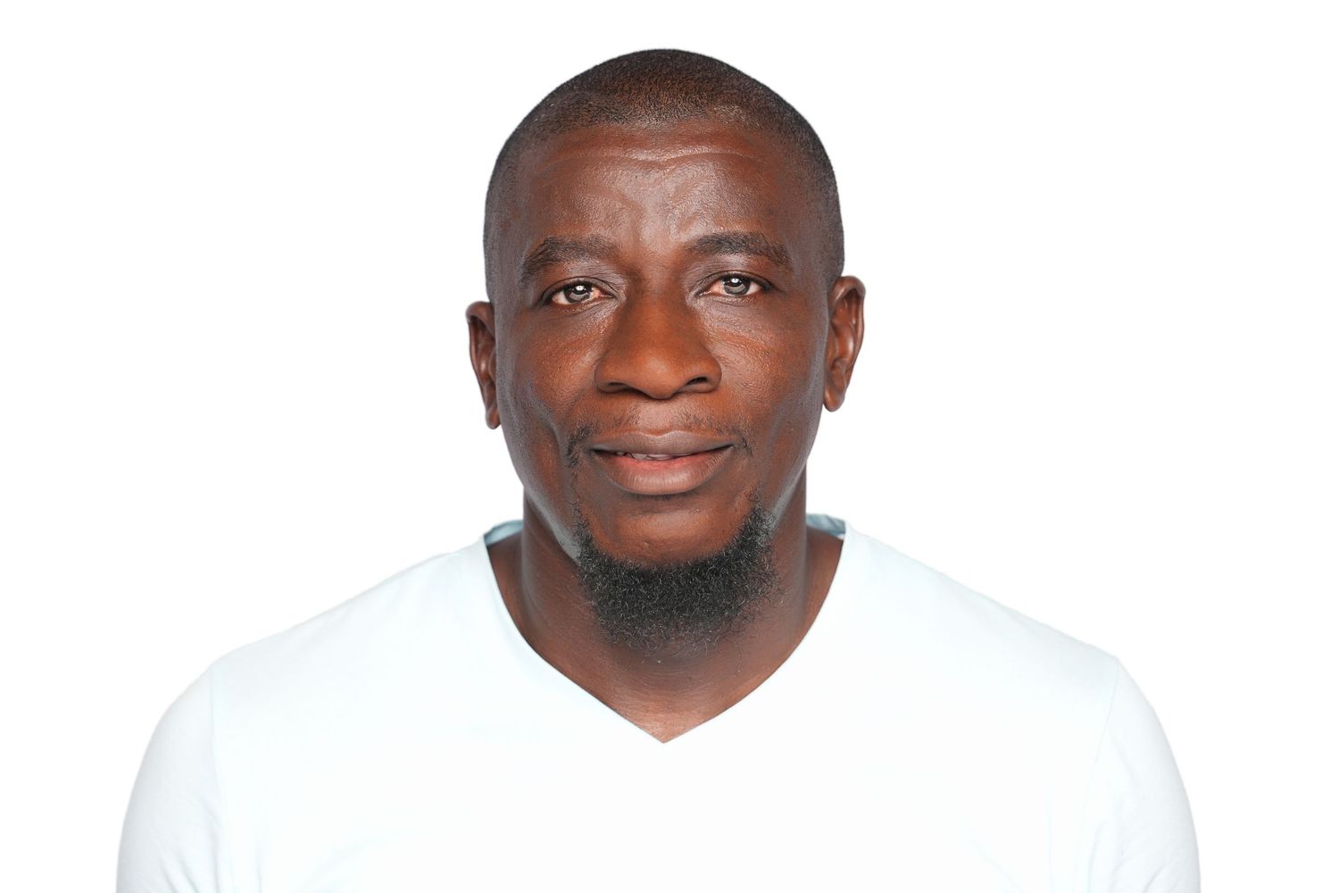 Portrait of a confident middle-aged black man with a goatee wearing a white v-neck shirt against white background.