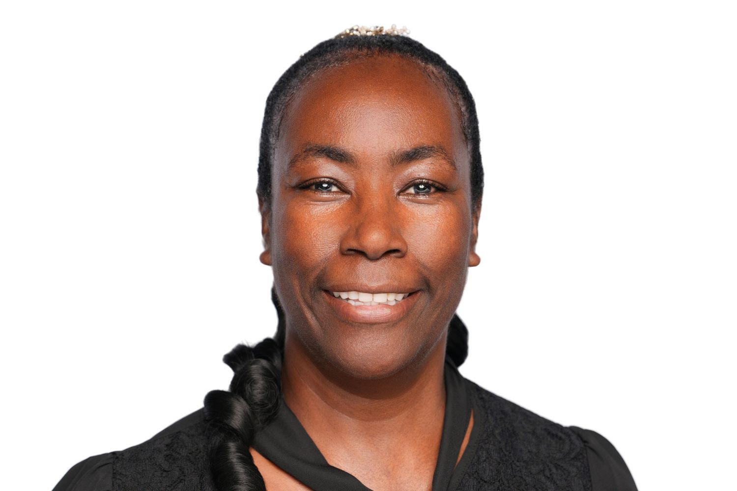 Professional headshot of a confident woman smiling, wearing a black top against a white background.