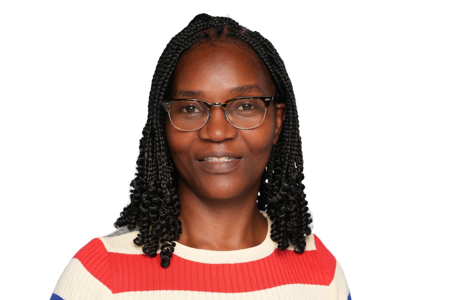 Woman with braided hair and glasses wearing a striped sweater, smiling against a white background.