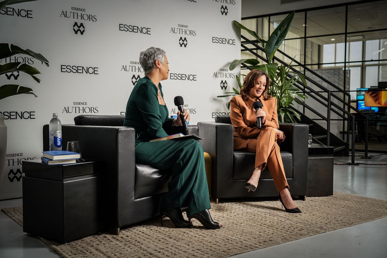 Two professional women seated on stage during an Essence Authors panel discussion event.