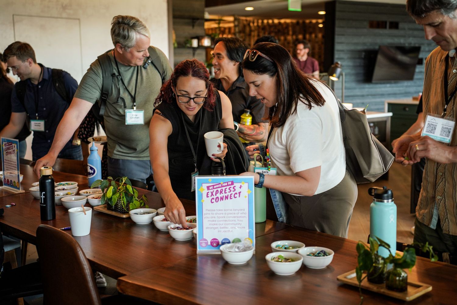 Group of people gathered around an Express and Connect activity table with bowls of candy.
