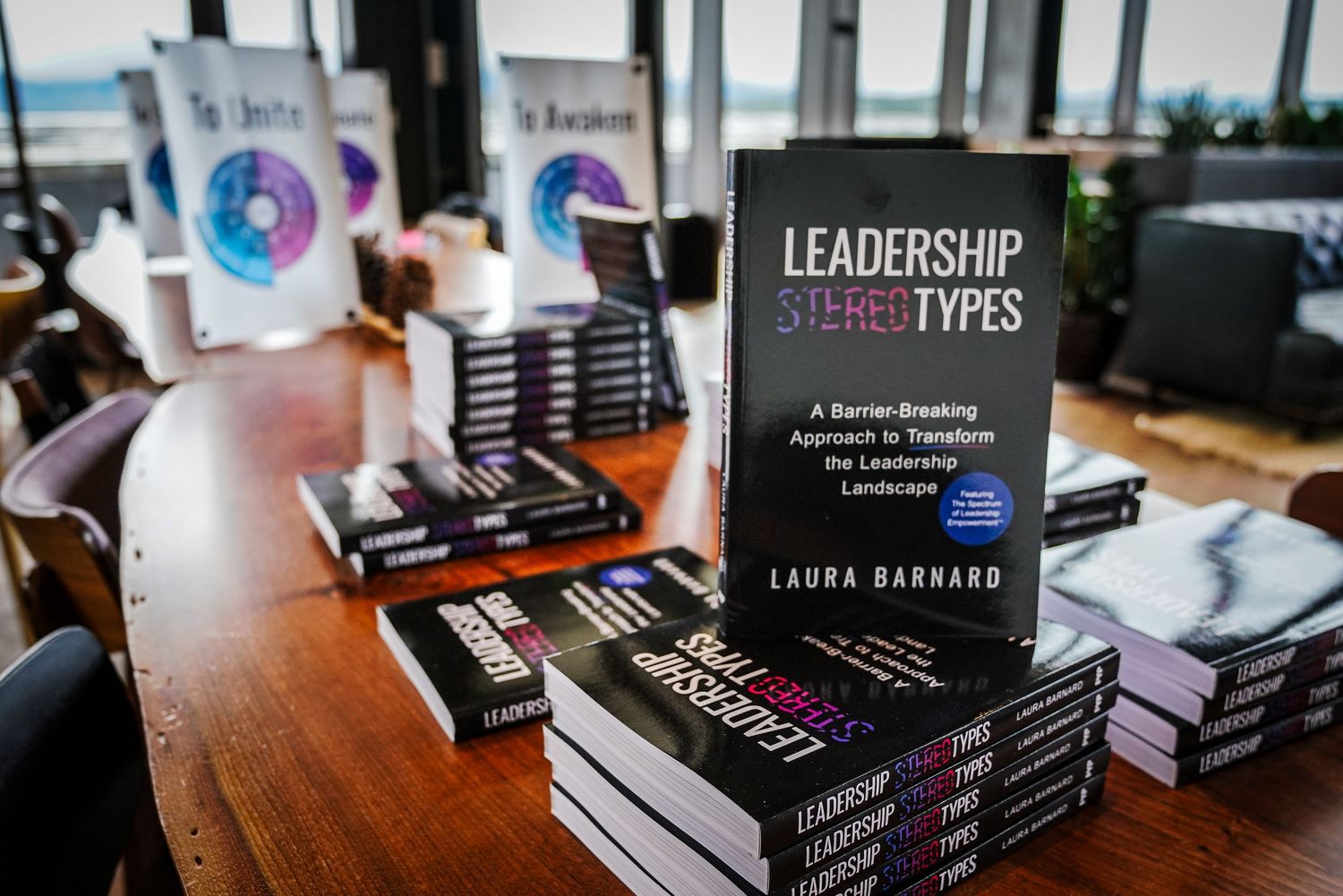 Stacks of Leadership Stereotypes book by Laura Barnard on wooden table.