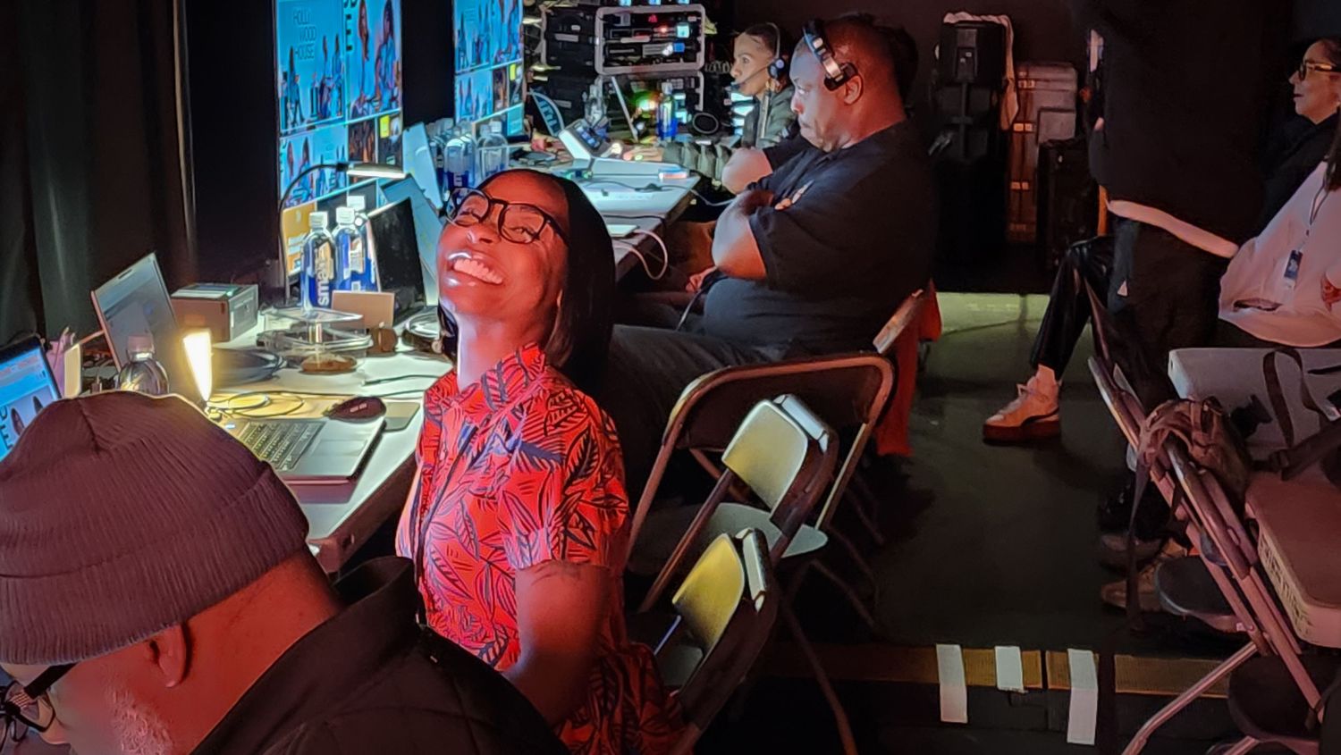 Woman relaxing in a chair during a theatrical production backstage in a dimly lit theater.