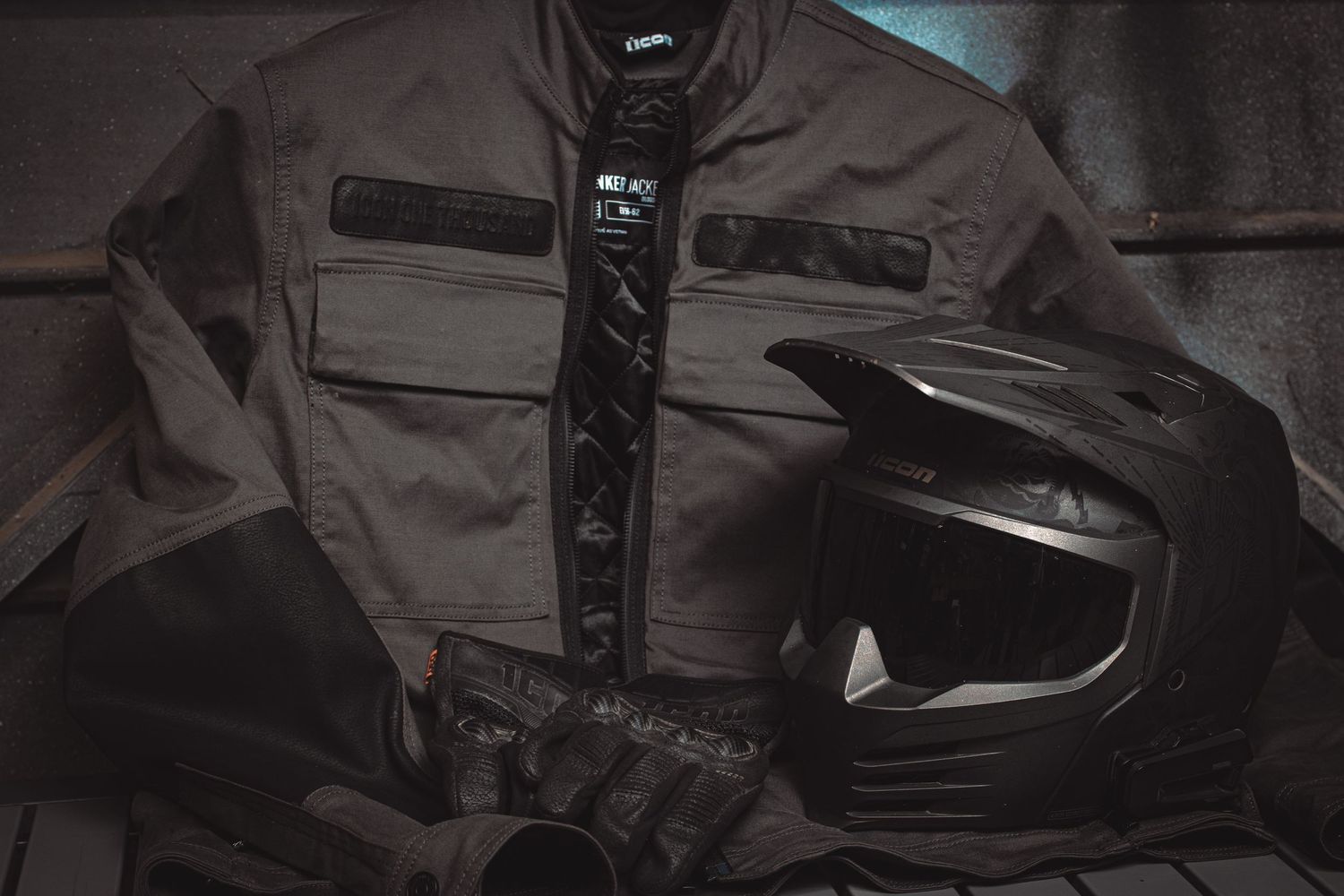 Motorcycle adventure gear flatlay featuring a textile jacket, full-face helmet, and riding gloves.