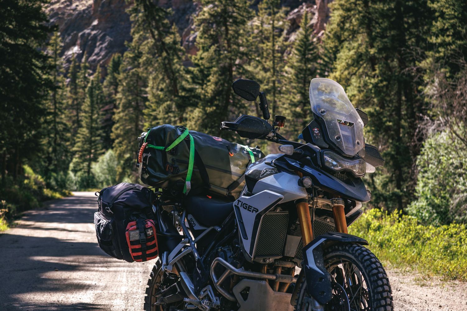 Adventure motorcycle loaded with gear parked on a mountain dirt road.