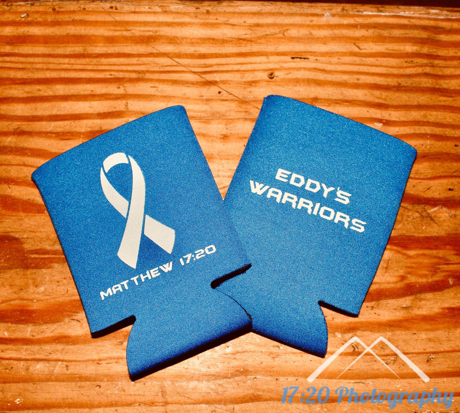 Blue koozie with white ribbon and Matthew 17:20 on one side, Eddy's Warriors text on the other side.
