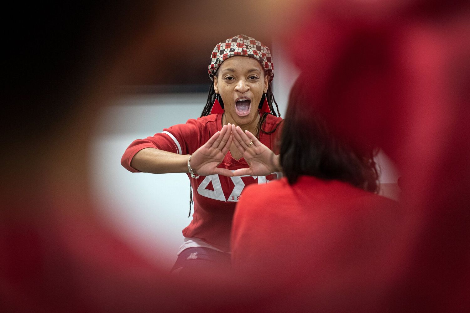A member of Delta Sigma Theta Sorority, Inc. chants as she forms a pyramid with her hands