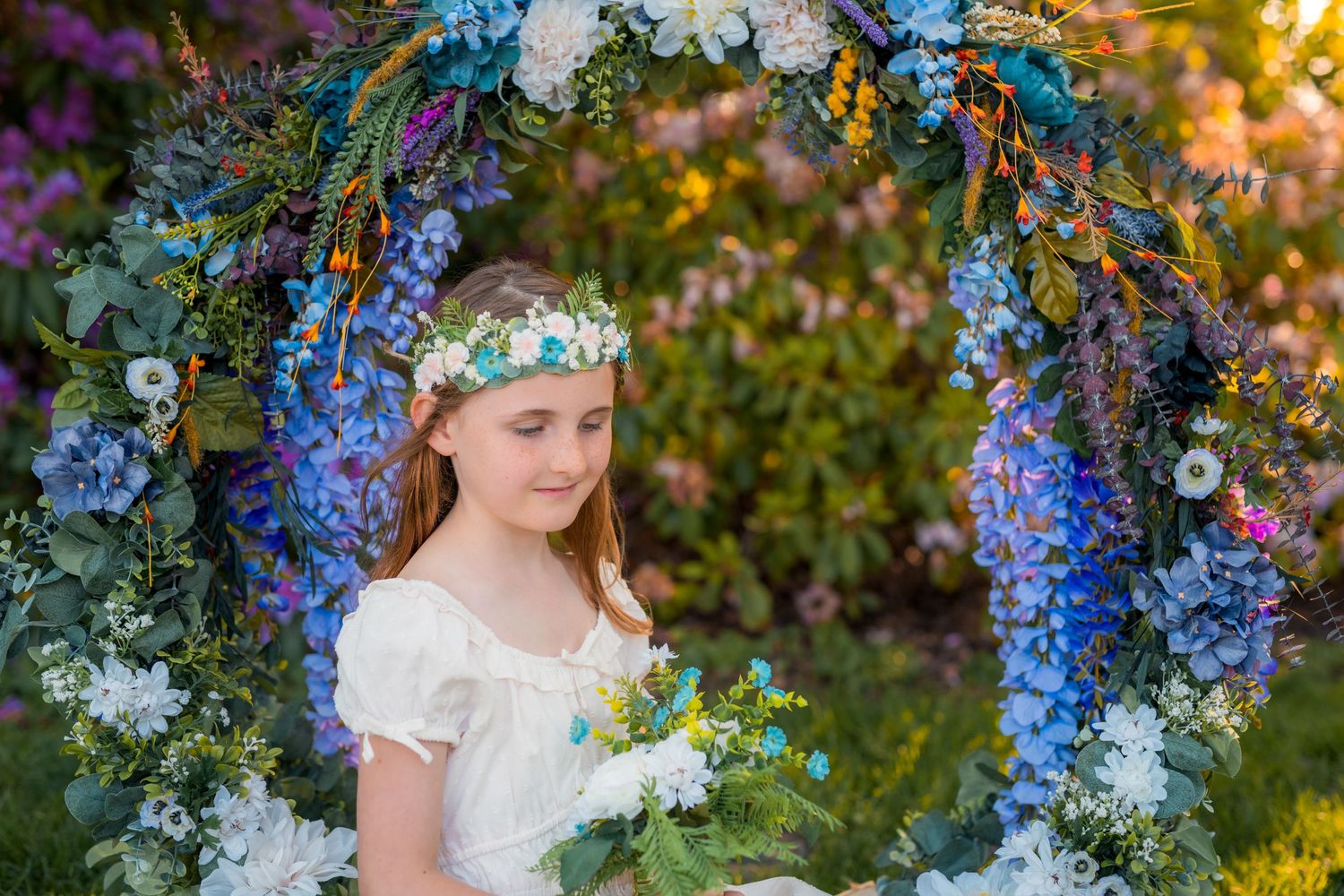 Whimsical portrait of a young girl in a garden-inspired setting at golden hour.