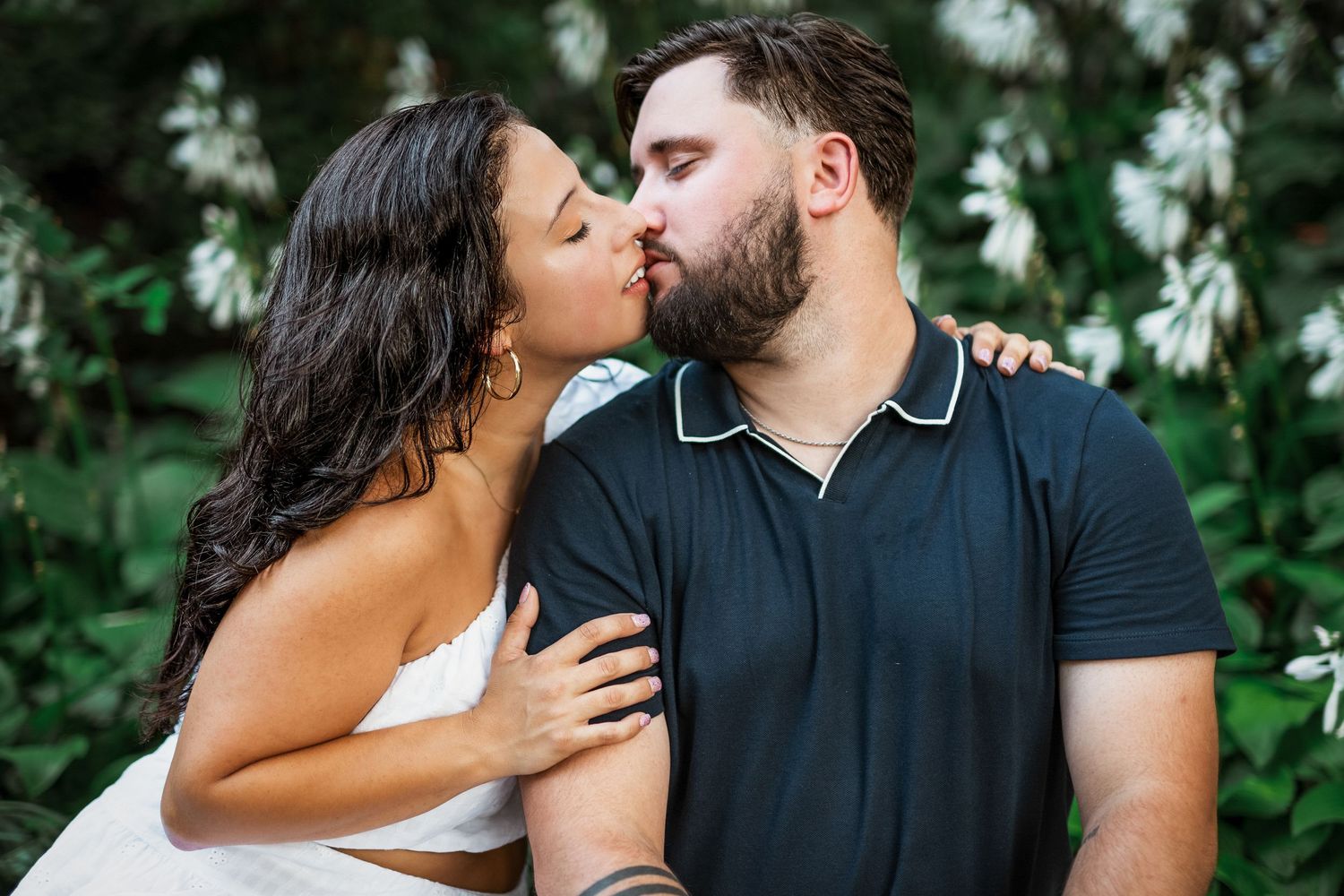 Romantic kiss between engaged couple in Amherstburg park, soft sunset lighting.