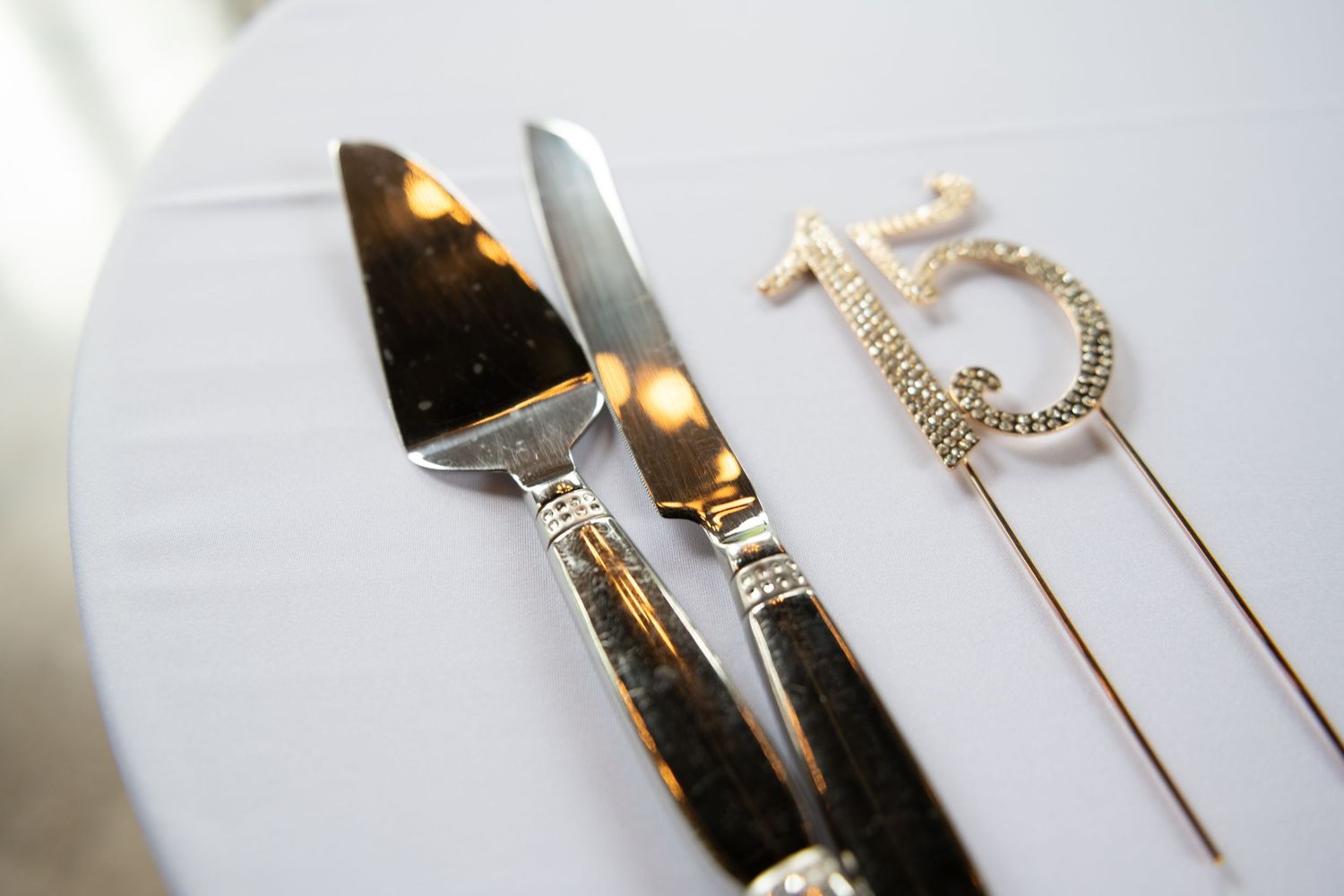 Wedding table settings with fine silverware and elegant place settings on white linens.