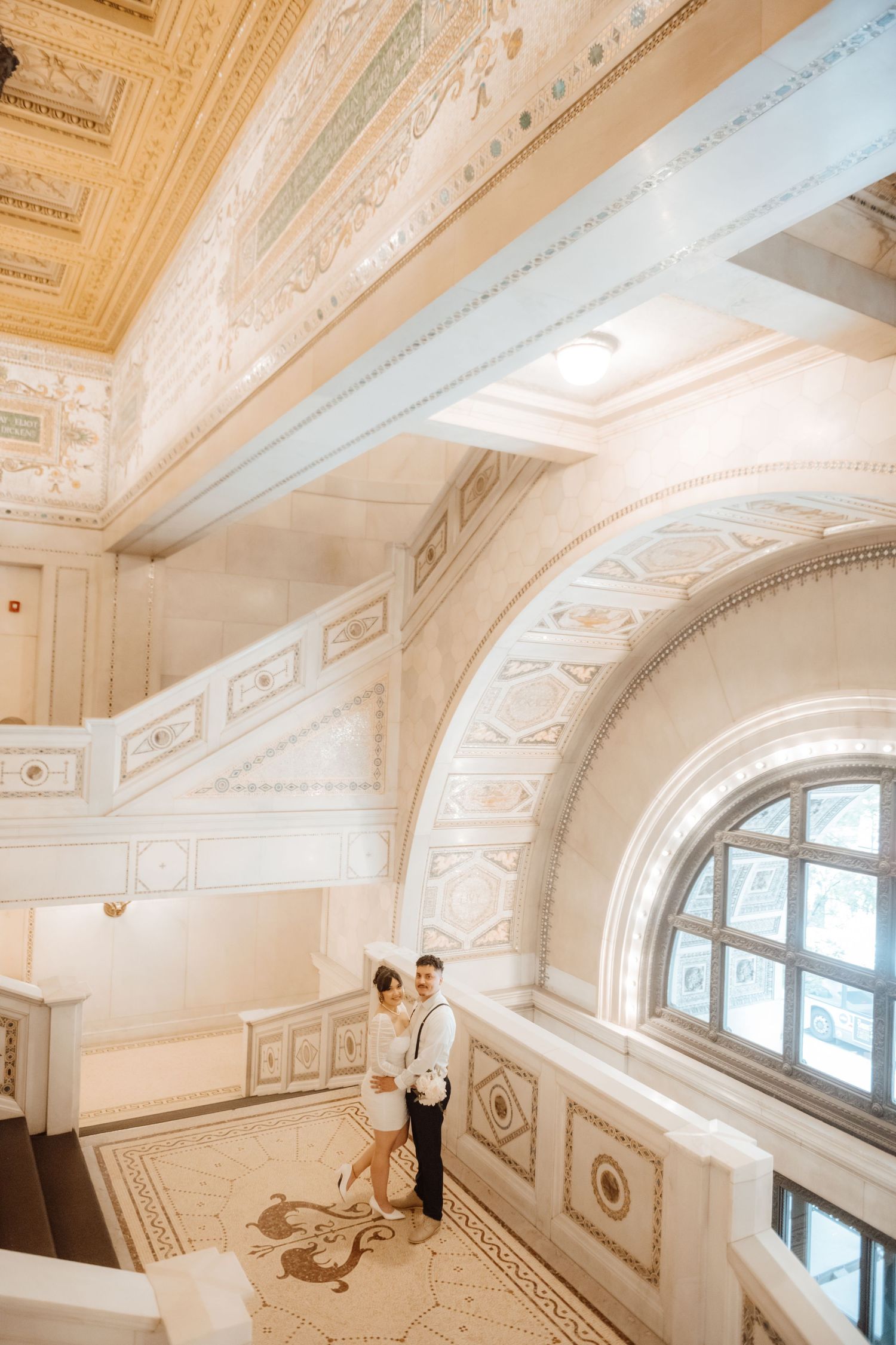 Grand architectural interior with ornate white ceiling details and arched windows.