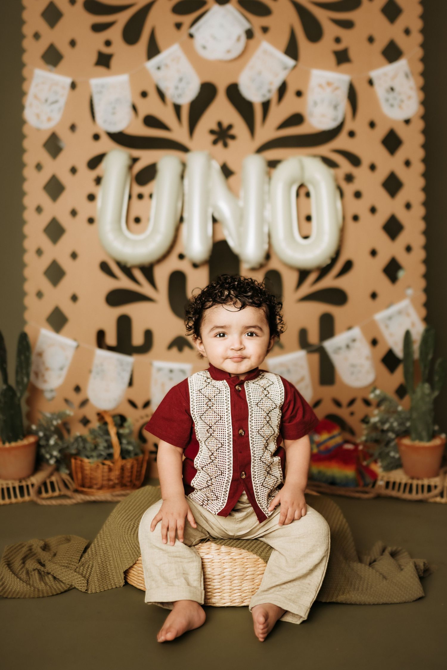 First birthday photo with southwestern themed backdrop and decorative elements.