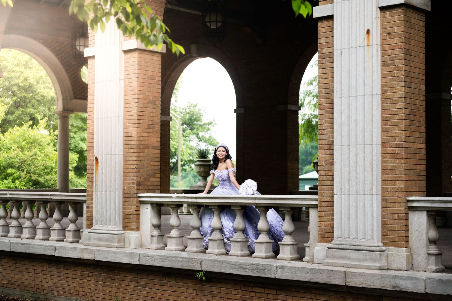 Classical architectural colonnade with brick pillars and arched details.