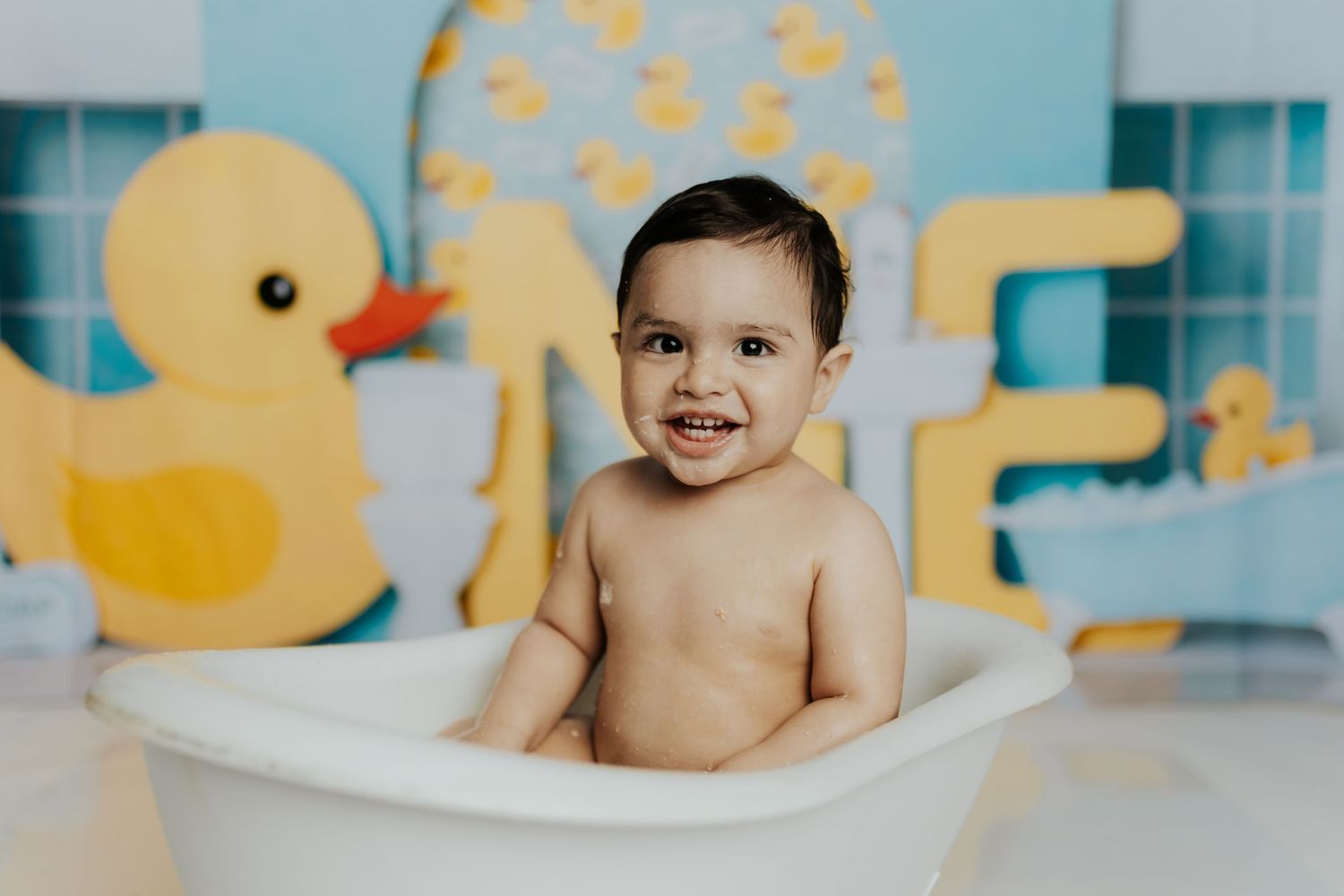 Cheerful bath time setup with rubber duck theme and blue tile backdrop.