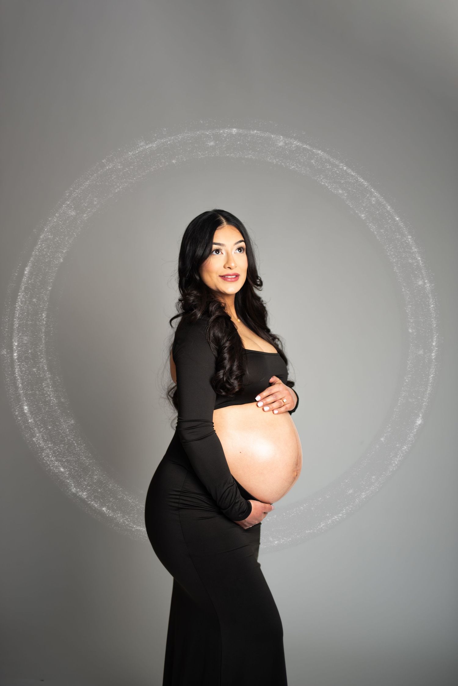 Creative maternity portrait with chalk circle drawings on grey studio background.