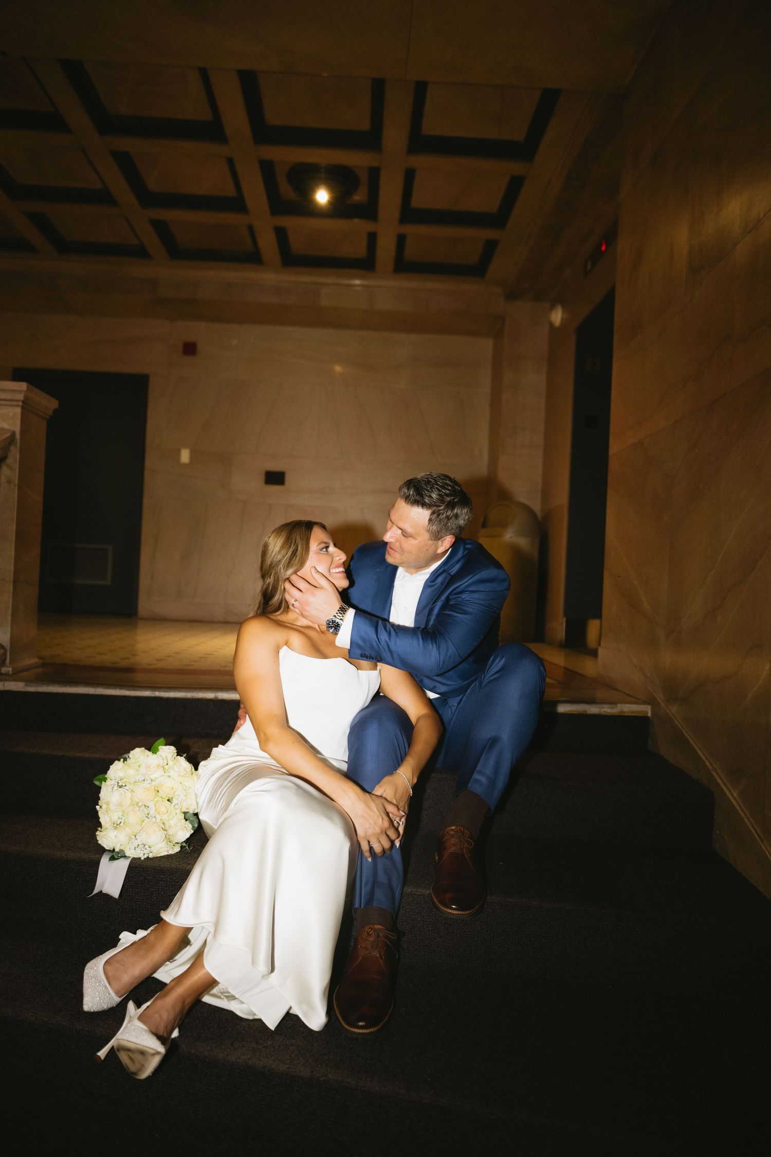 Romantic wedding photos captured in a dimly lit elegant venue with dramatic lighting.