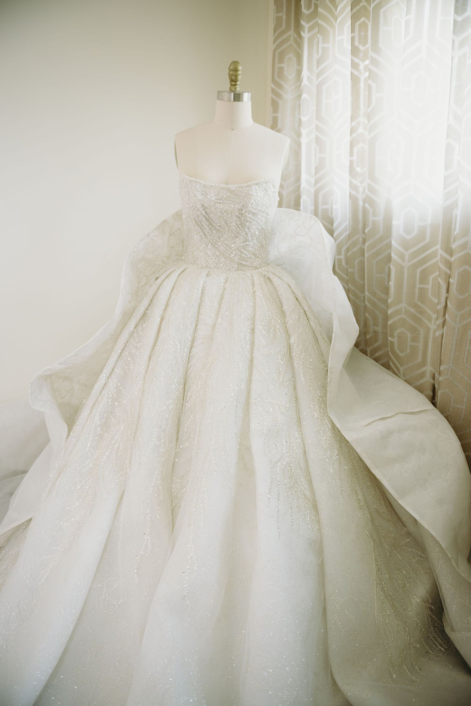 Stunning white ballgown wedding dress with full skirt displayed in natural light.