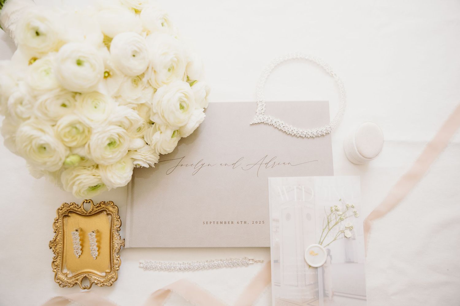 Elegant wedding stationery with white floral arrangements and delicate details on a light background.