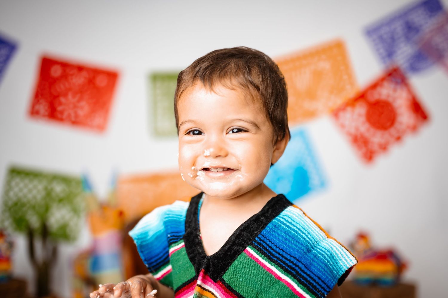 Colorful party decorations with festive papel picado banners in background.