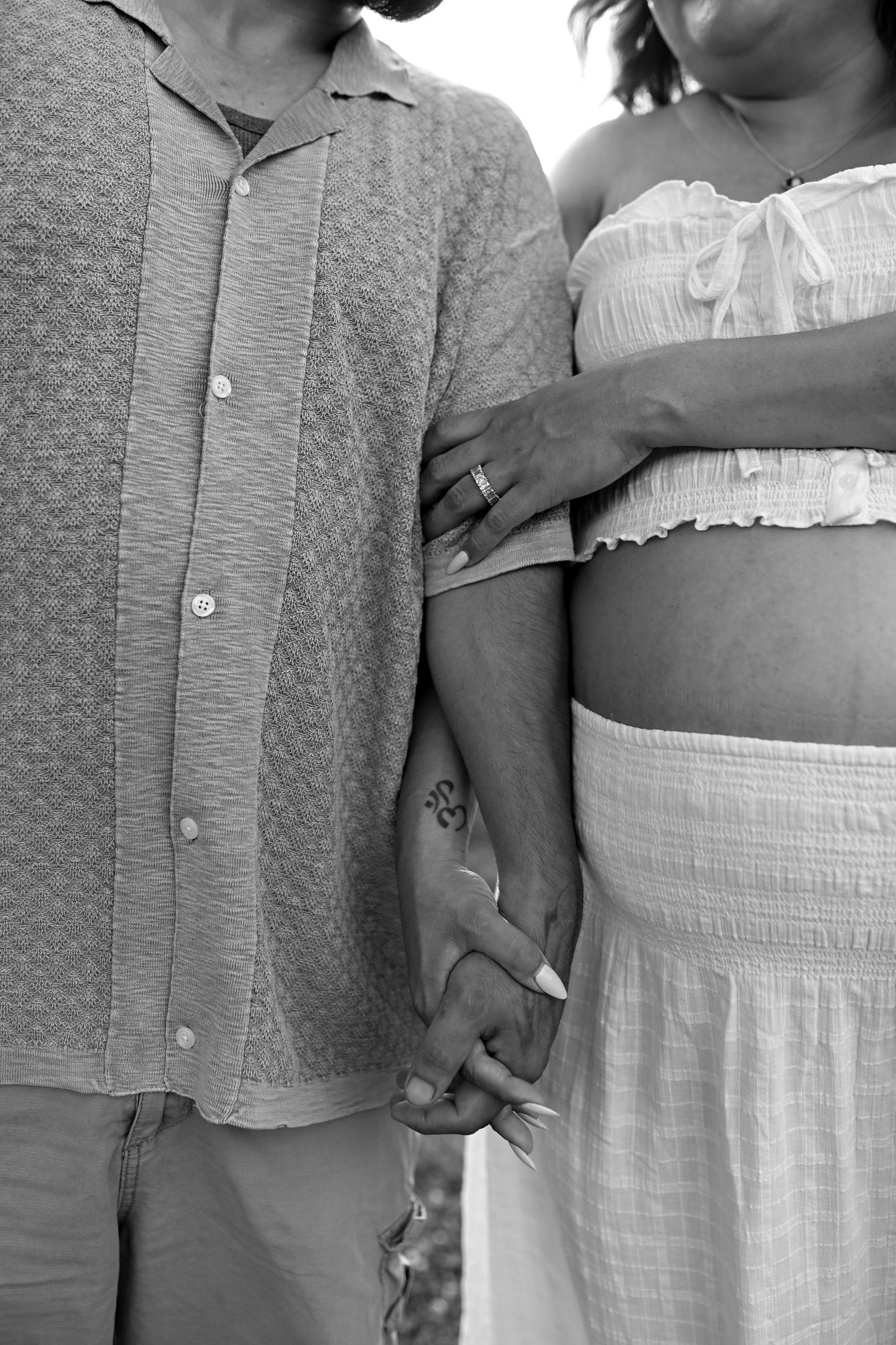 Close-up black and white detail shots showing hands and clothing textures.