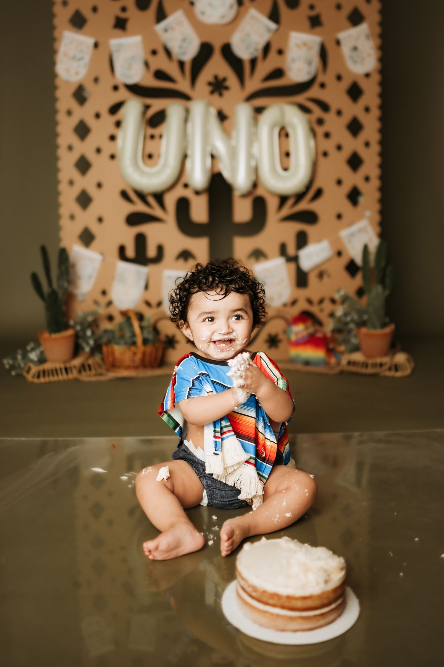 Festive first birthday celebration with Mexican-inspired backdrop and cake.