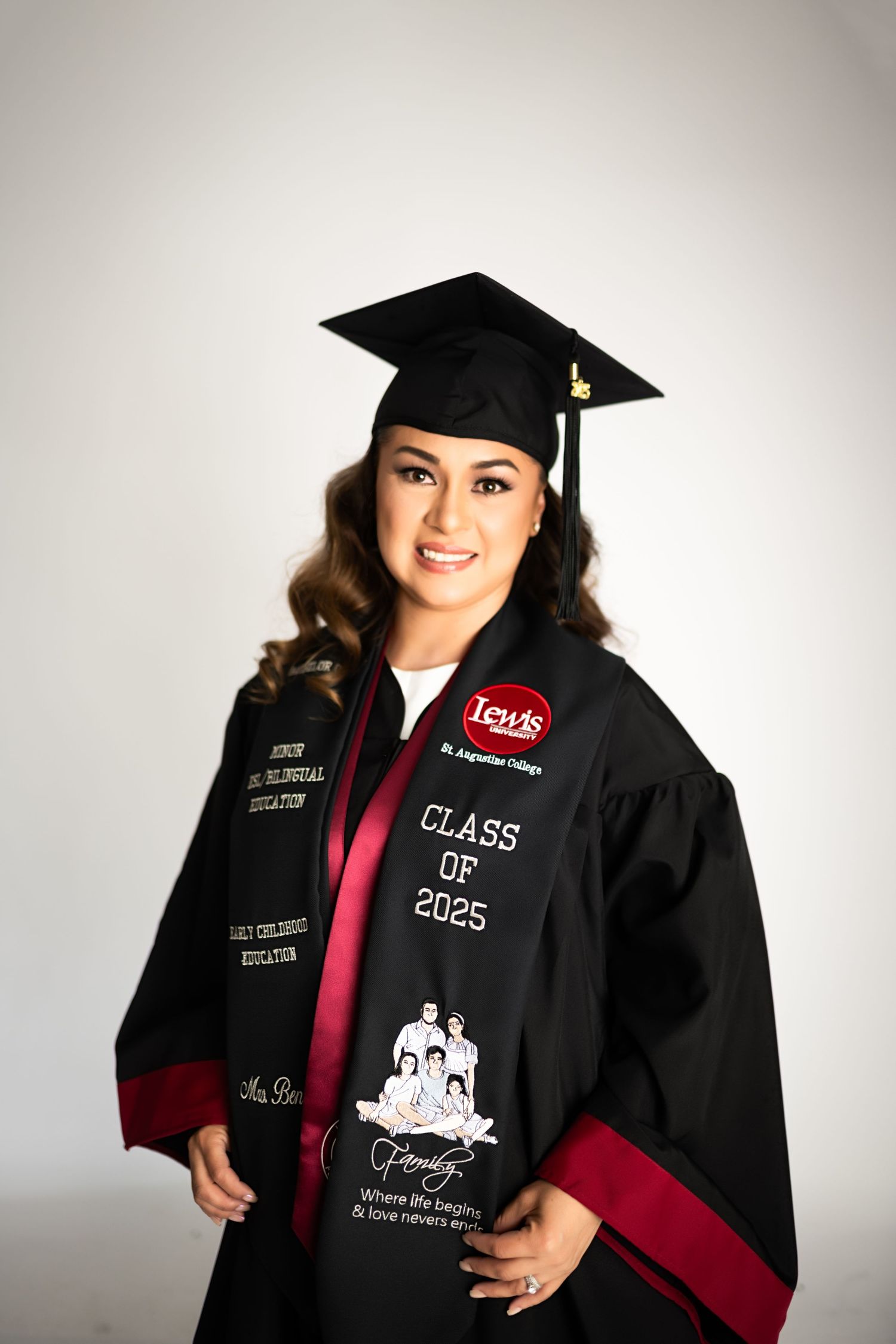 Decorated graduation cap and gown against white studio background.