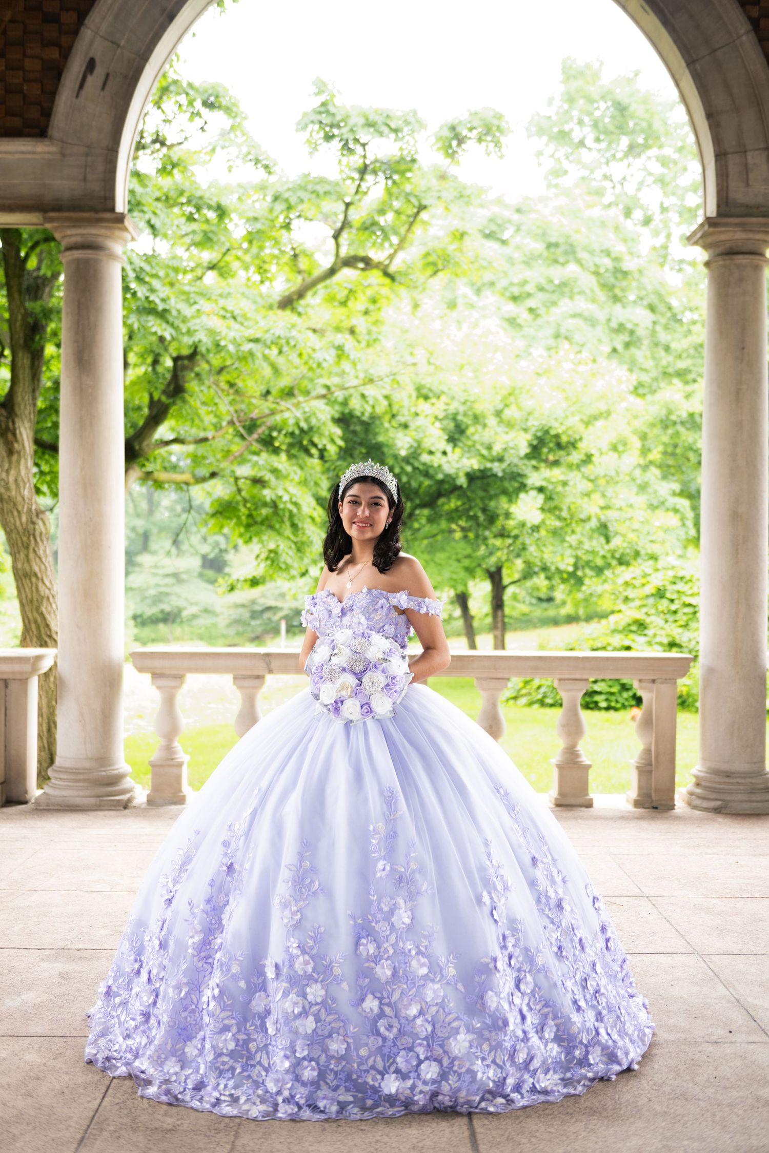 Elegant lavender and white ball gown photographed in stone archway setting.