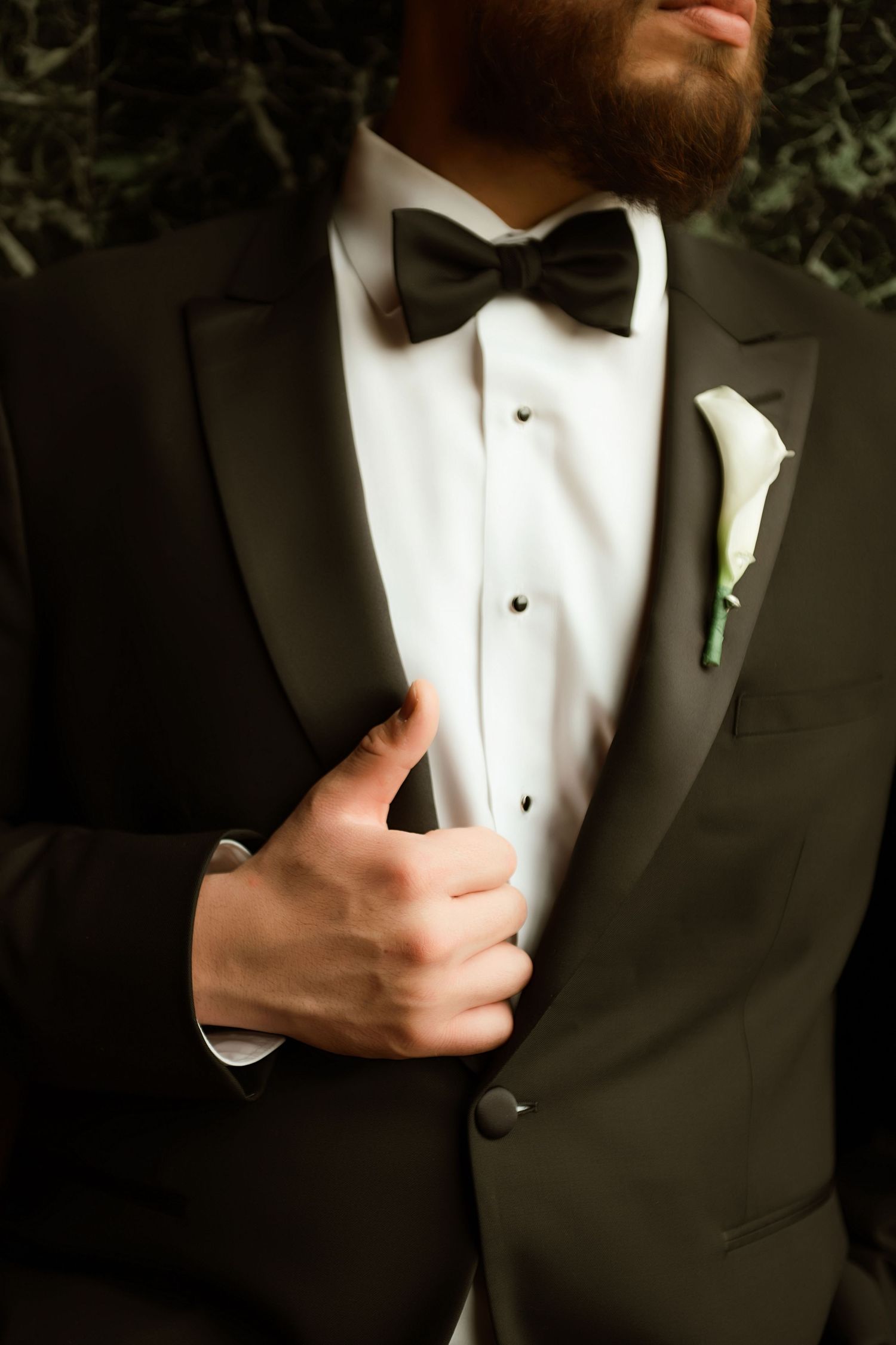 Close-up shots of a formal black tuxedo with white dress shirt and bow tie shown from different angles.