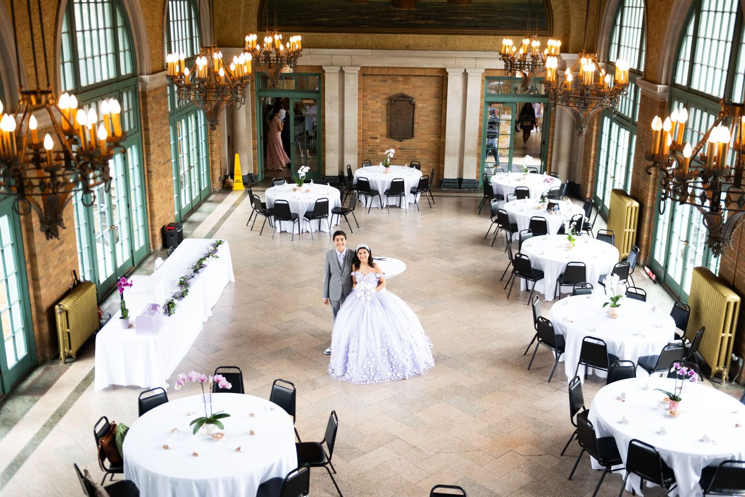 Elegant ballroom setup with crystal chandeliers and round tables for formal event.