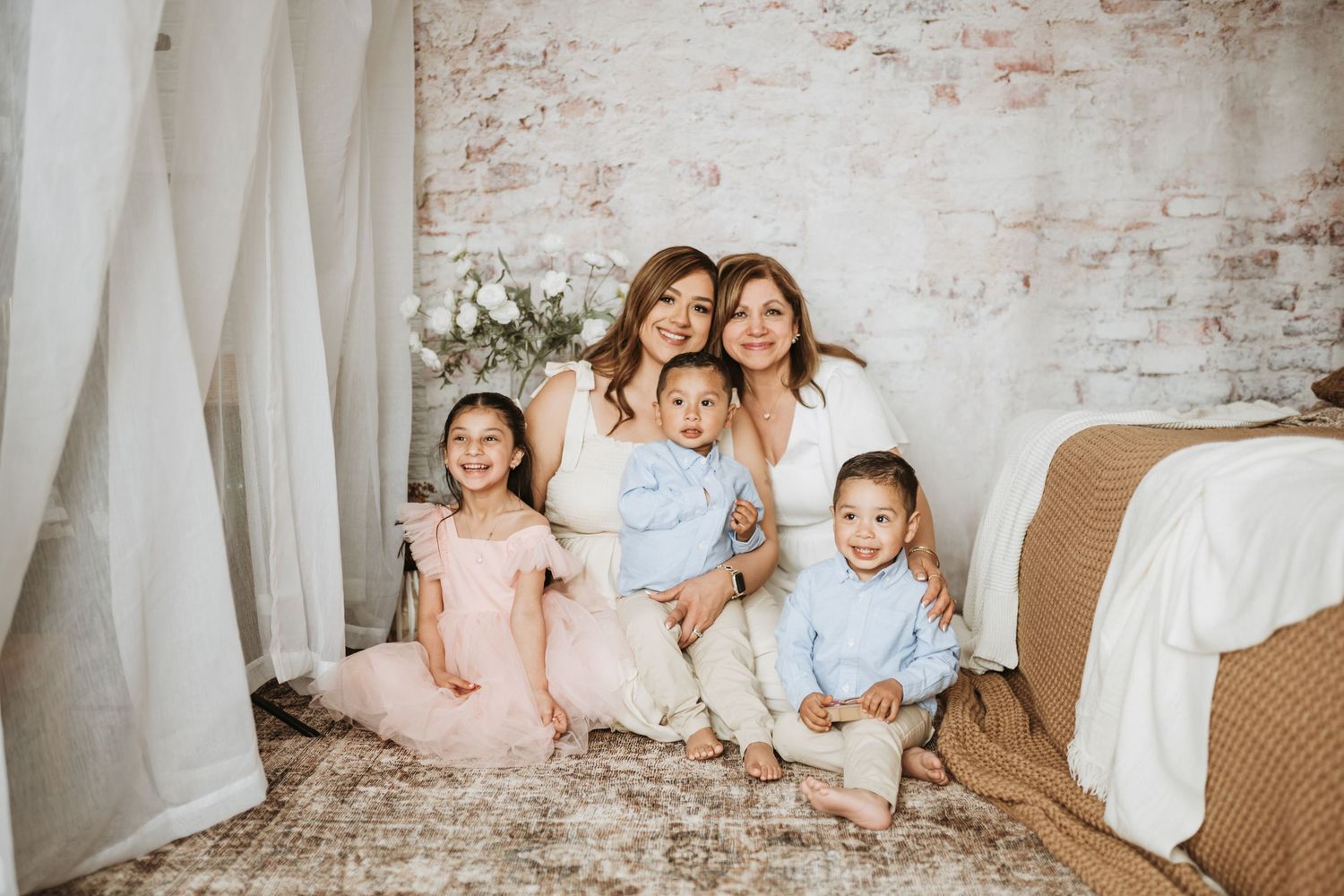 Lifestyle photo session on couch with soft textiles and exposed brick wall background.