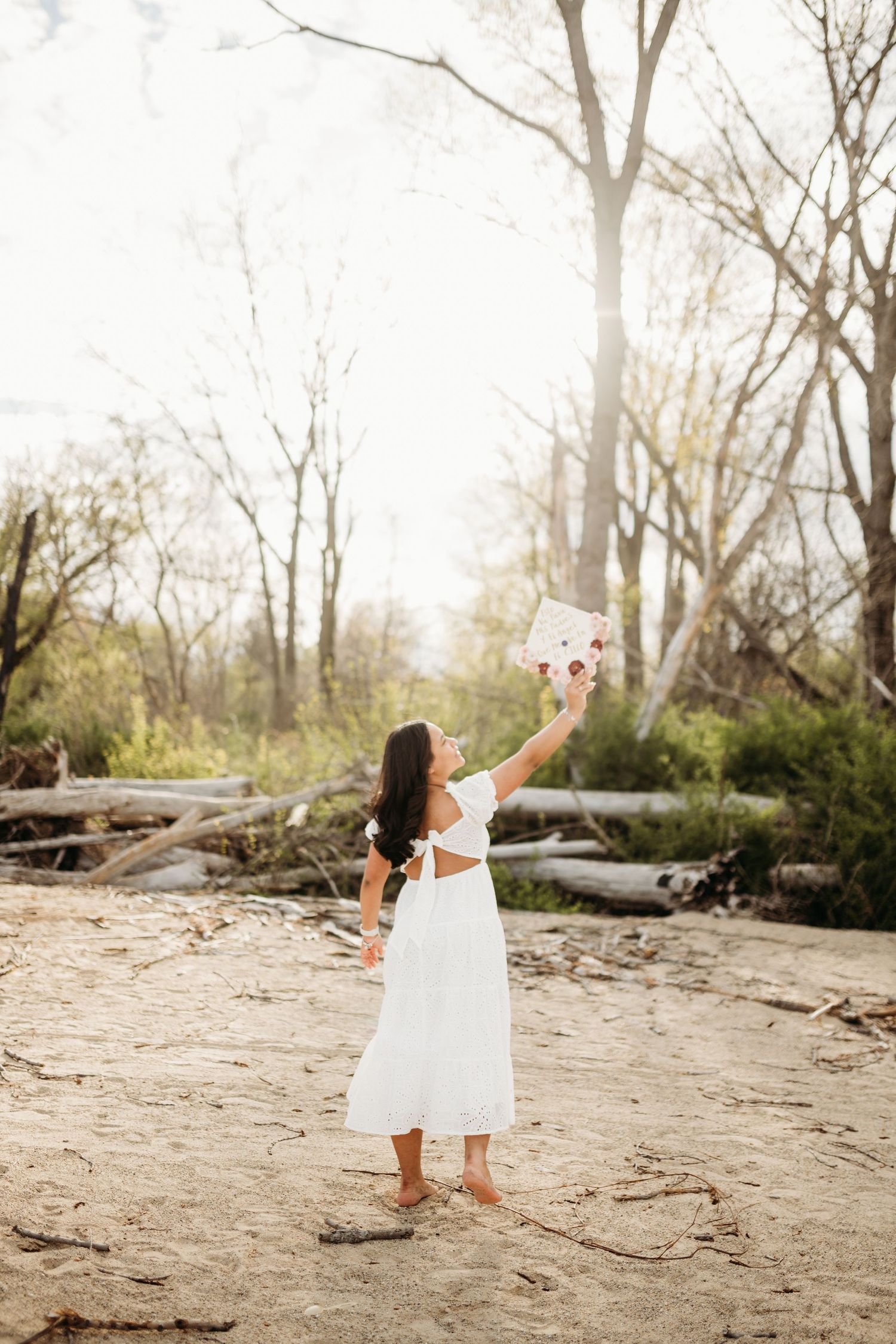 Playful movements captured on a sandy beach with trees in background.