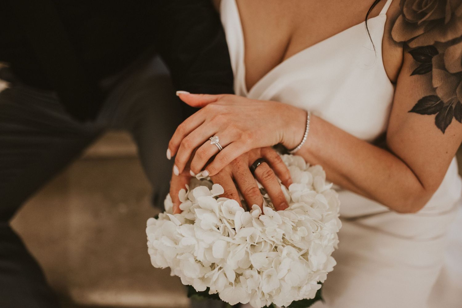 Detail shot of white floral bouquet and dress fabric.