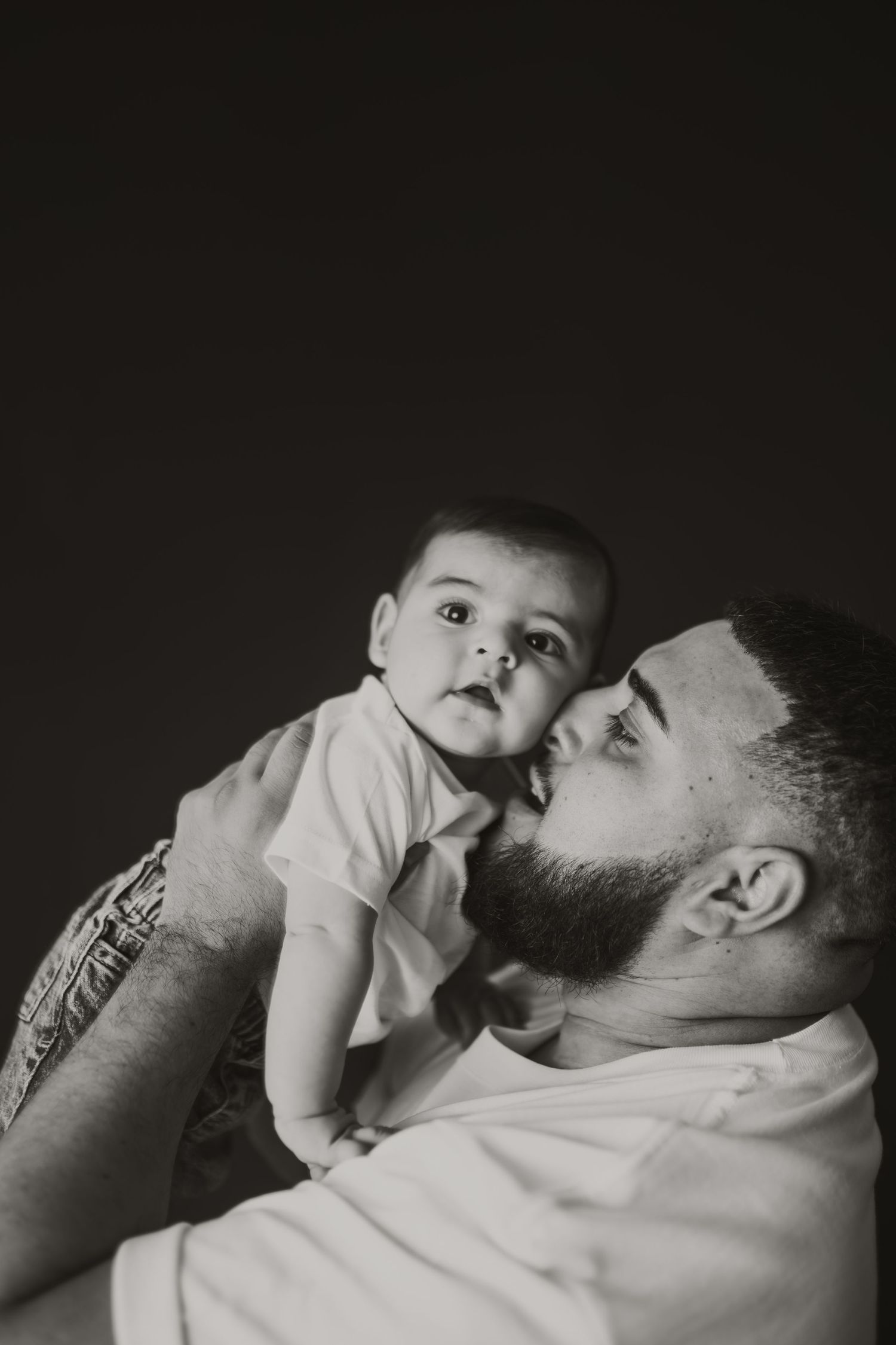 Black and white intimate portraits showing tender moments between parent and baby.