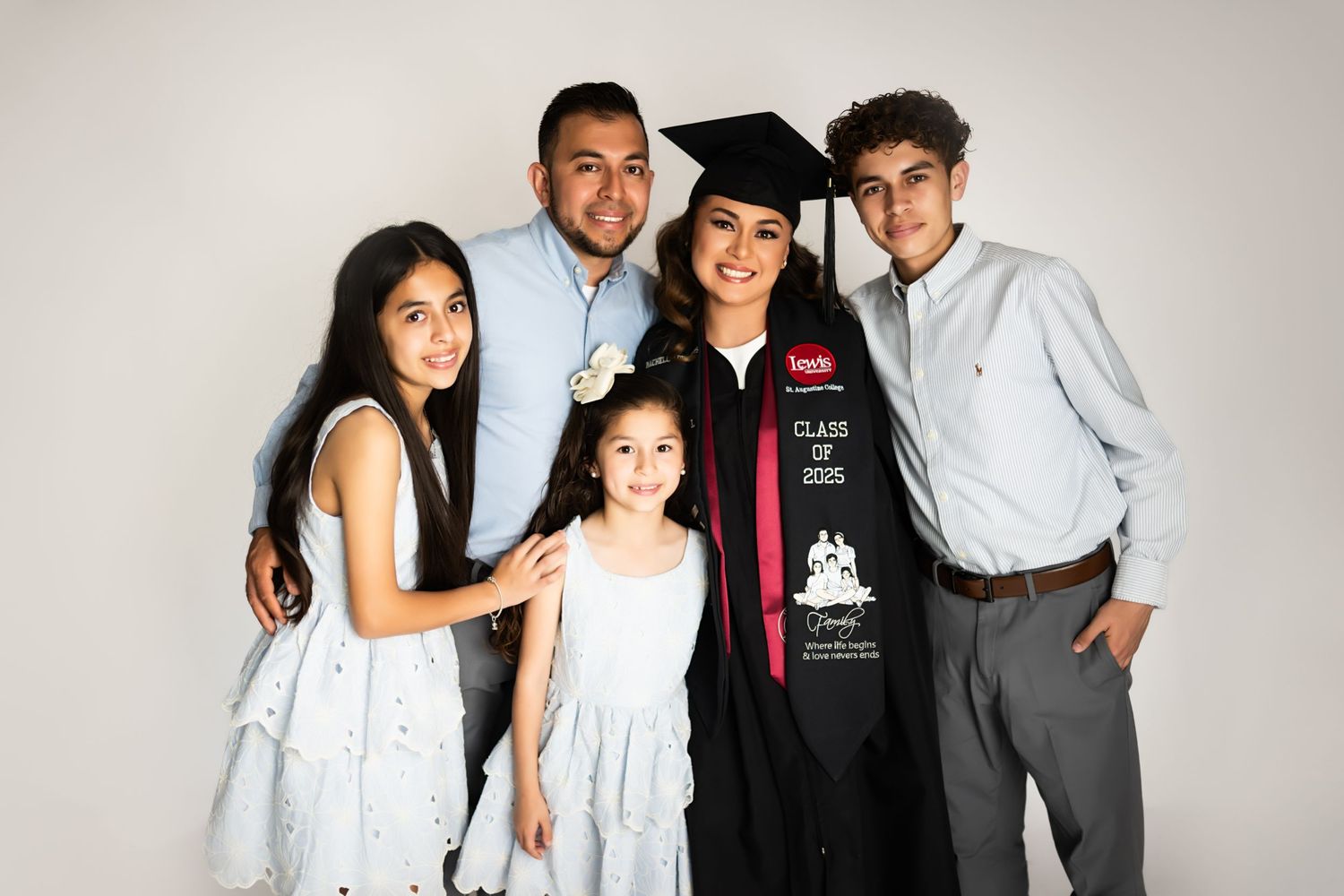 Family group poses together in studio celebrating graduation achievement.