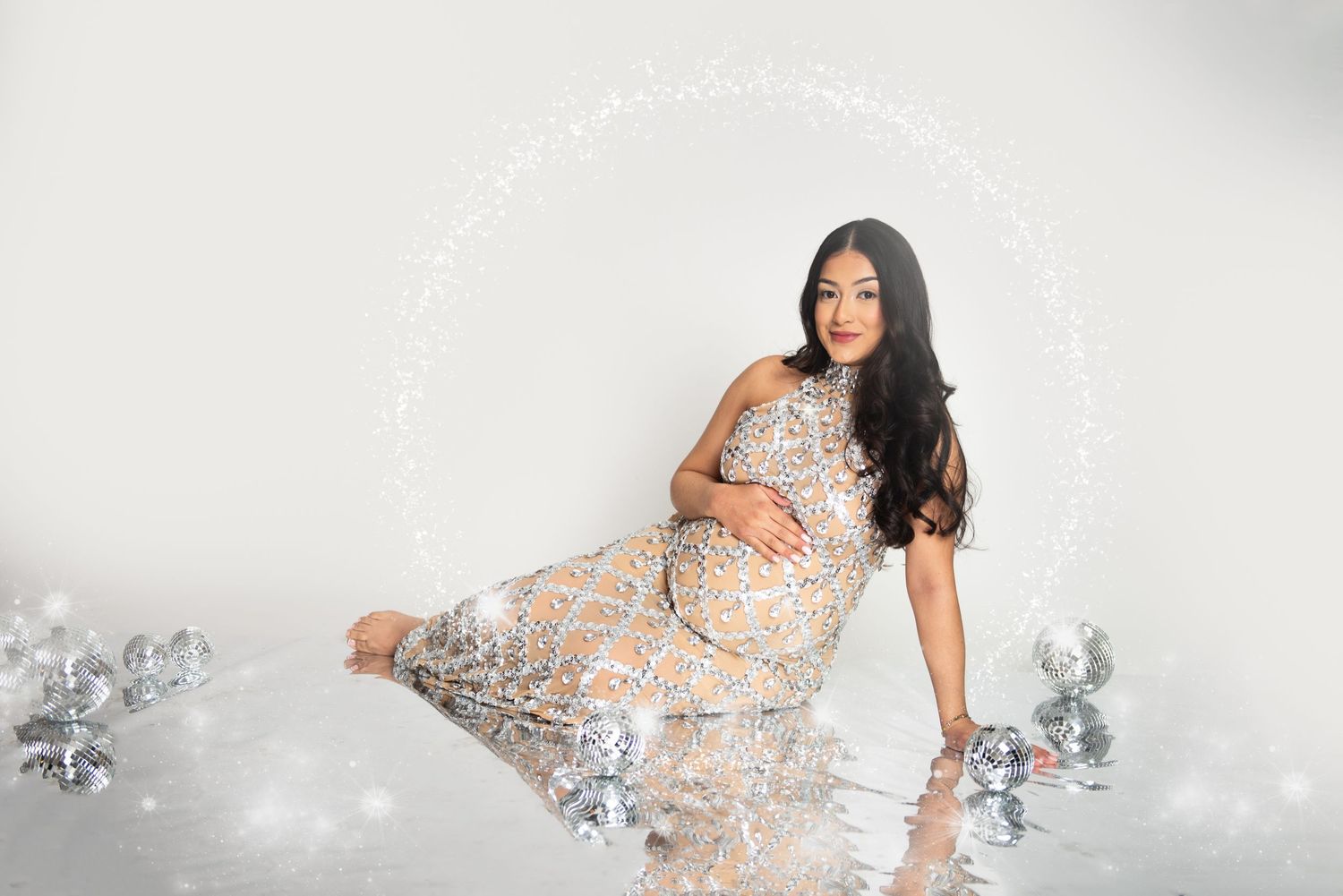 Maternity photo session with sparkly overlay effects on white background.