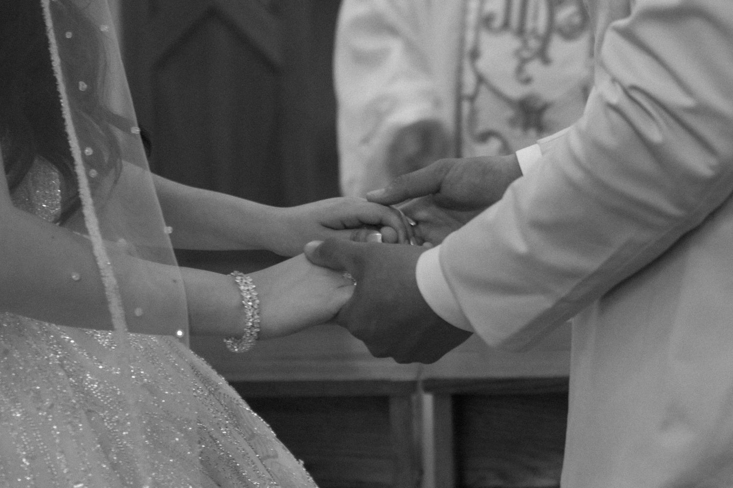 Close-up details of hands during a wedding ceremony.