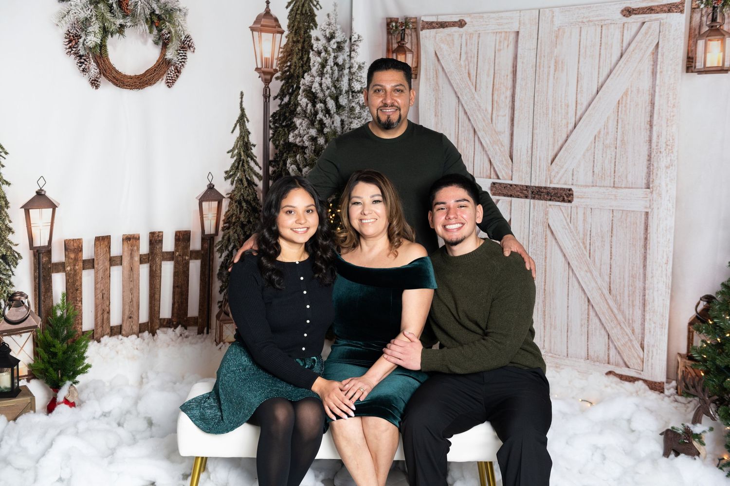 Winter family photo session with rustic barn doors and holiday decorations.